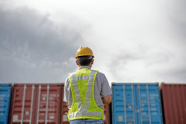 Man in front of containers on a containerterminal